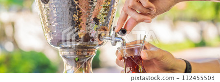 Drinking Traditional Turkish Tea with Turkish tea cup and copper tea pot BANNER, LONG FORMAT 112455503
