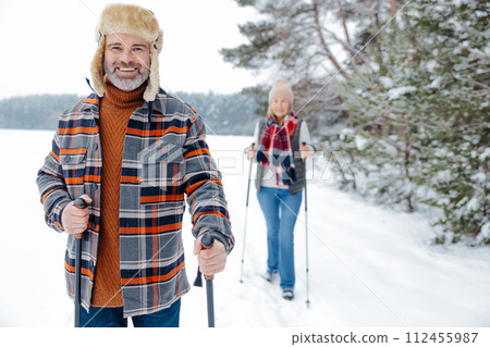 Man and woman looking enjoyed and contented while walking with sticks 112455987