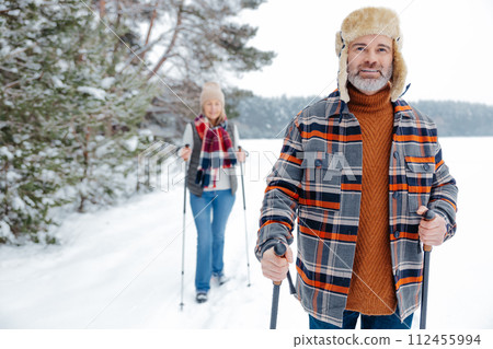Couple on a walk with scandinavian sticks 112455994