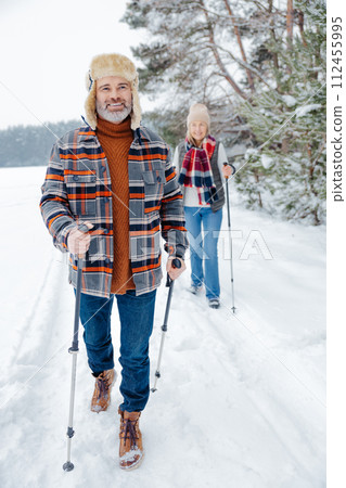 Couple on a walk with scandinavian sticks 112455995