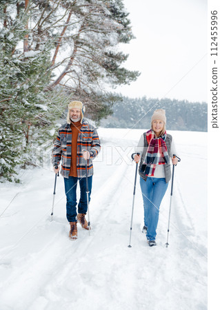 Couple on a walk with scandinavian sticks 112455996