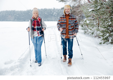 Couple on a walk with scandinavian sticks 112455997