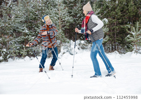 Couple on a walk with scandinavian sticks 112455998