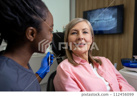 Woman visiting dentistry clinic for professional teeth treatment doctor holding instrument tool Woman visiting dentistry clinic for professional teeth treatment doctor holding instrument tool 112456099