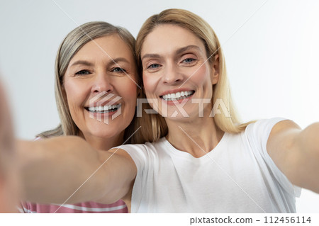 Mother and daughter having good time together and looking happy 112456114