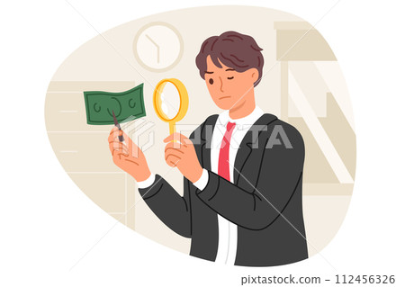 Expert examines counterfeit money via magnifying glass to look for inaccuracies in fake banknotes 112456326