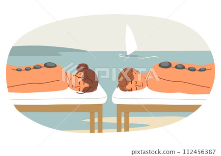 Outdoor SPA and hot stone massage for man with woman lying on sea and enjoying rejuvenation therapy 112456387