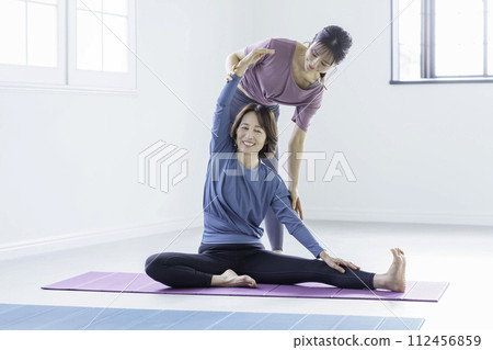 A young woman and a middle-aged woman stretching 112456859
