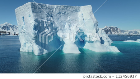 Huge Antarctic iceberg drift blue ocean sunny day. Giant ice glacier at polar nature environment. Global warming. Climate change. Cinematic ecology scene. Antarctica travel and exploration. Panorama 112456937