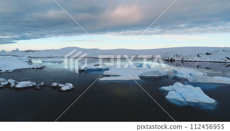 Fly over evening Antarctica. Serene beauty of a glaciers surrounded by pristine icy ocean landscape. Untouched wilderness of South Pole. Wildlife in Antarctica, travel and exploration. Drone flight 112456955