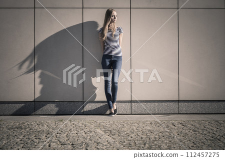woman casual style against stone grunge wall 112457275