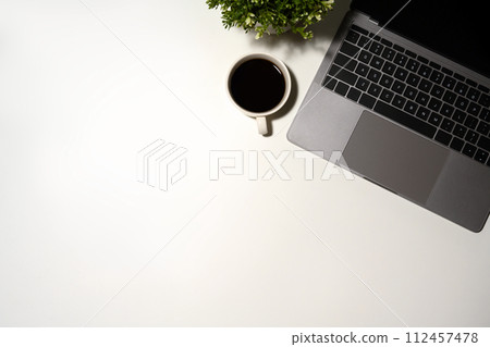 White office desk with laptop, coffee cup and potted plant. Top view with copy space 112457478
