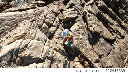 Aerial view of woman runner running on sunrise seaside rocks 112458889