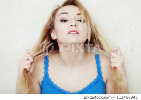 Blond woman teenage girl showing her damaged dry hair 112458948