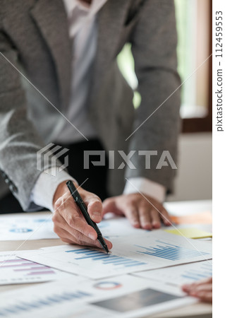 Close up young man with calculator counting making notes at home, hand is writing in a notebook. Savings finances concept Close up young man with calculator counting making notes at home, hand is writing in a notebook. Savings finances concept 112459553