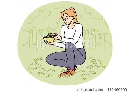 Woman gathering leaves in forest  112460803