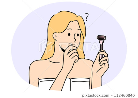 Confused woman with razor in hands think of shaving Confused woman with razor in hands think of shaving 112460840