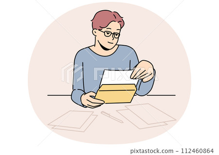 Man in glasses reading letter at table 112460864