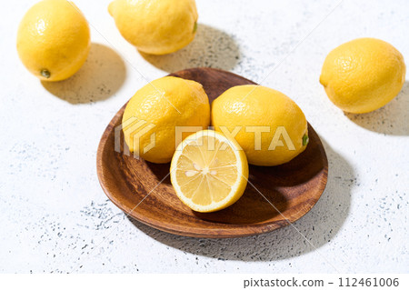 Domestic lemons on a wooden plate 112461006