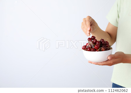 Ripe cherry fruits in a bowl on a white background Ripe cherry fruits in a bowl on a white background 112462062