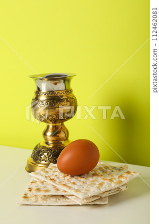 Matzo, egg and cup on yellow background Matzo, egg and cup on yellow background 112462081