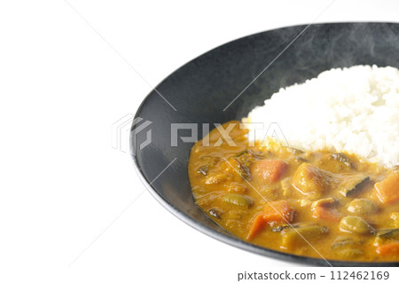 A photo of piping hot curry rice with plenty of vegetables such as pork, pumpkin, and carrots against a white background. 112462169
