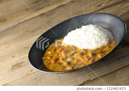Hot curry rice with plenty of vegetables such as pork, pumpkin, and carrots. 112462425