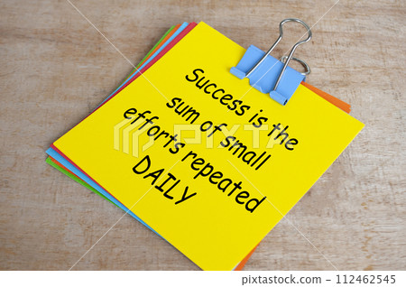Success is a sum of small efforts repeated daily text on yellow notepad. Encouragement concept Success is a sum of small efforts repeated daily text on yellow notepad. Encouragement concept 112462545