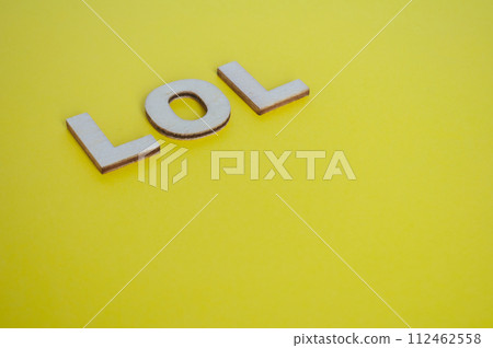 LOL wooden letters representing laugh out loud on yellow background 112462558