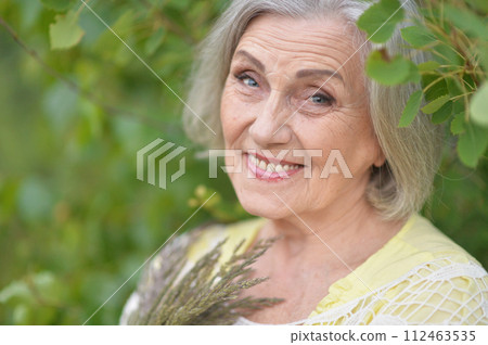 Portrait of happy senior woman posing at forest Portrait of happy senior woman posing at forest 112463535