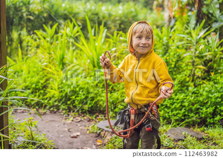 Little boy in a rope park. Active physical recreation of the child in the fresh air in the park. Training for children Little boy in a rope park. Active physical recreation of the child in the fresh air in the park. Training for children 112463982