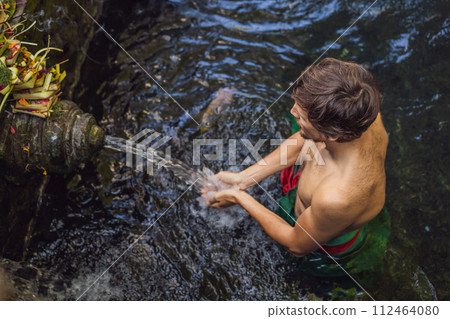 Man in holy spring water temple in bali. The temple compound consists of a petirtaan or bathing structure, famous for its holy spring water 112464080