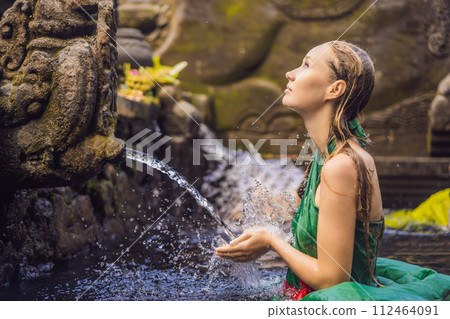 Woman in holy spring water temple in bali. The temple compound consists of a petirtaan or bathing structure, famous for its holy spring water 112464091