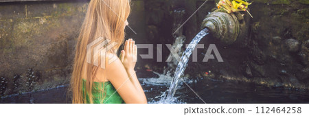 Woman in holy spring water temple in bali. The temple compound consists of a petirtaan or bathing structure, famous for its holy spring water BANNER, LONG FORMAT Woman in holy spring water temple in bali. The temple compound consists of a petirtaan or bathing structure, famous for its holy spring water BANNER, LONG FORMAT 112464258
