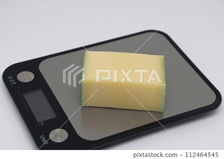 Pieces of cheese on the scales. Weight loss, diet and weight control Pieces of cheese on the scales. Weight loss, diet and weight control 112464545