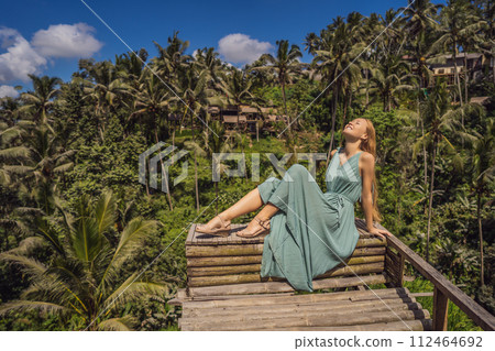 Beautiful young woman walk at typical Asian hillside with rice farming, mountain shape green cascade rice field terraces paddies. Ubud, Bali, Indonesia. Bali travel concept Beautiful young woman walk at typical Asian hillside with rice farming, mountain shape green cascade rice field terraces paddies. Ubud, Bali, Indonesia. Bali travel concept 112464692
