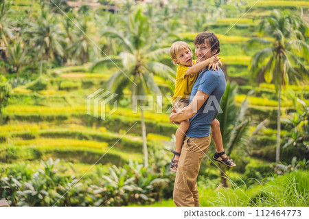 Dad and son travelers on Beautiful Rice Terraces against the background of famous volcanoes in Bali, Indonesia Traveling with children concept 112464773