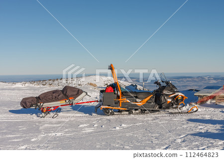 Snowmobile with stretcher mountain rescue service in front of Silesian House in krkonose mountains. 112464823