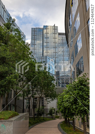BRUSSELS, BELGIUM, June 23, 2023: Urban Oasis: Green Courtyard Amongst Glass Office Towers BRUSSELS, BELGIUM, June 23, 2023: Urban Oasis: Green Courtyard Amongst Glass Office Towers 112464927