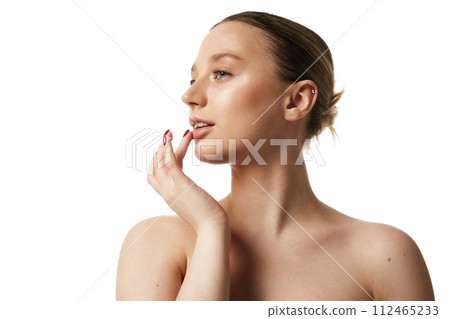 Young beautiful woman with bare shoulders gently touching her lips against white studio background. Profile view. 112465233