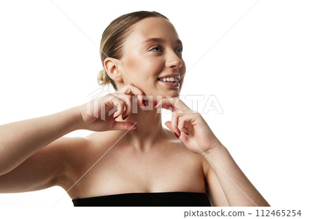 Young beautiful woman with bare shoulders doing massage to prevent double chin against white studio background. Young beautiful woman with bare shoulders doing massage to prevent double chin against white studio background. 112465254