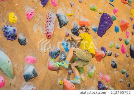 little boy climbing a rock wall in special boots. indoor 112465702