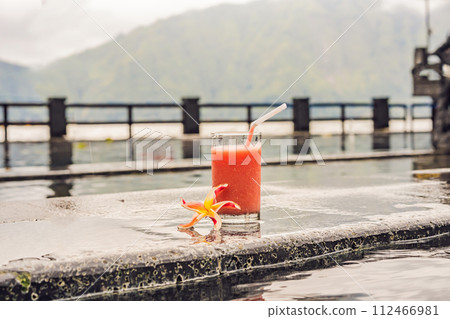 A glass of guava juice on the background of a lake and mountains. Healthy eating concept 112466981