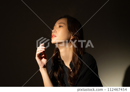 A woman smoking a cigarette 112467454