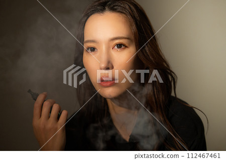 A woman smoking a cigarette 112467461
