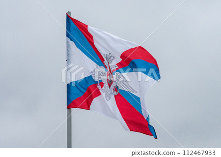 The flag of the Ministry of Defense of the Russian Federation is flying in the wind against a cloudy sky. The flag of the Ministry of Defense of the Russian Federation is flying in the wind against a cloudy sky. 112467933