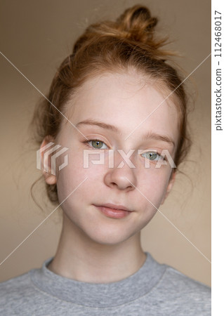 Portrait of a Caucasian cute and smart teenage girl with beautiful green eyes and red hair 112468017