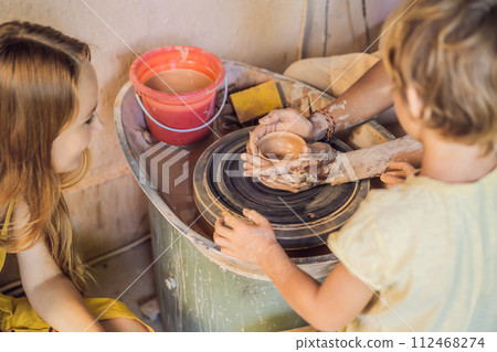 mother and son doing ceramic pot in pottery workshop 112468274
