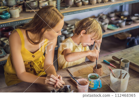 mother and son doing ceramic pot in pottery workshop 112468365