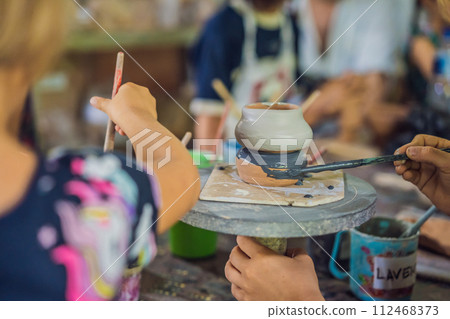 mother and son doing ceramic pot in pottery workshop 112468373